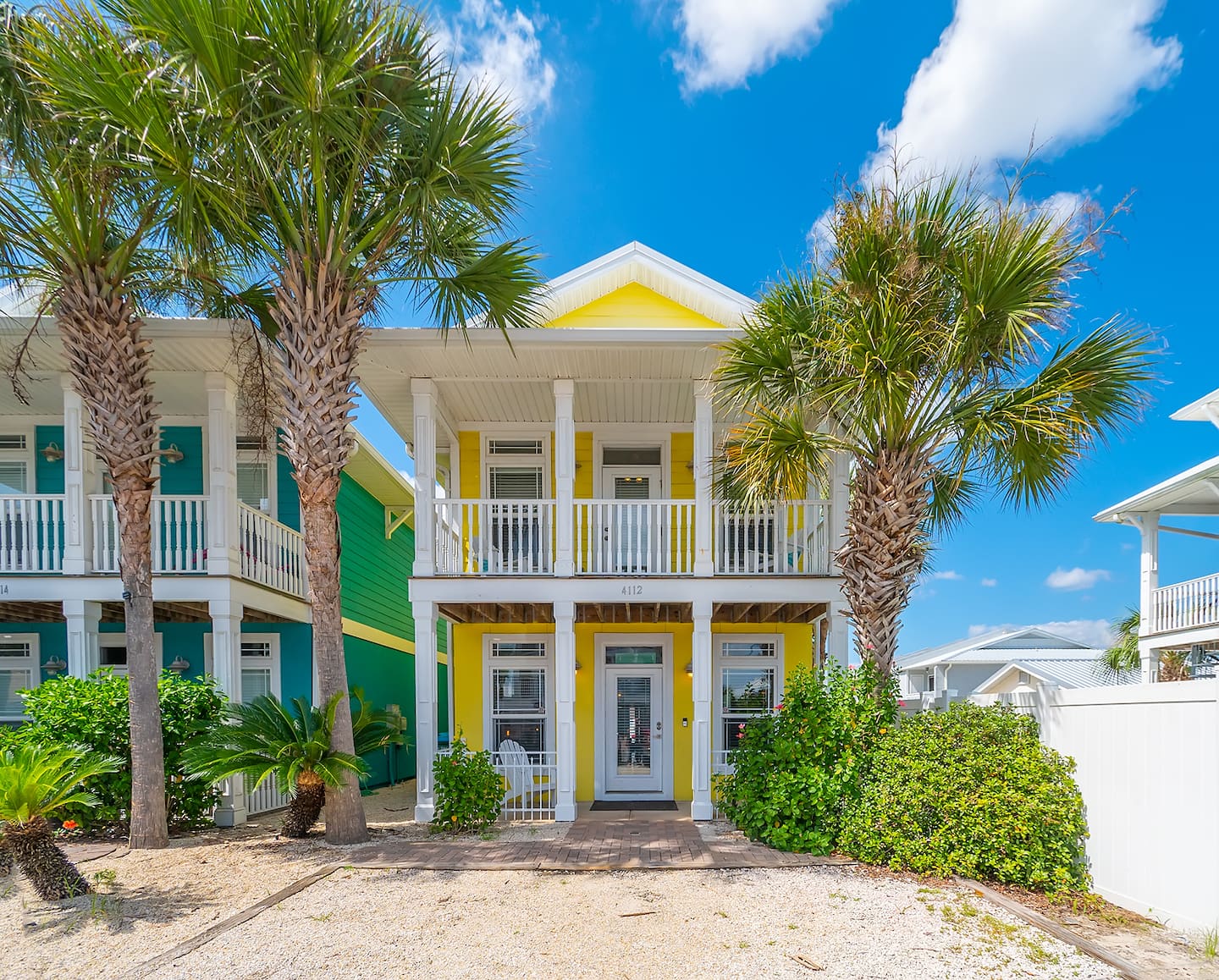Albacore Adventure, a colorful two-story Panama City Beach vacation home framed by palm trees